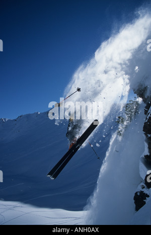 Ein Skifahrer, der Sprung von einer Klippe in das Hinterland des Kicking Horse, British Columbia, Kanada. Stockfoto