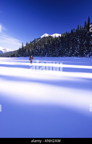 Backcountry Skifahrer auf gefrorenen Isaac See; Bowron Lakes Provincial Park im Winter, Britisch-Kolumbien, Kanada. Stockfoto