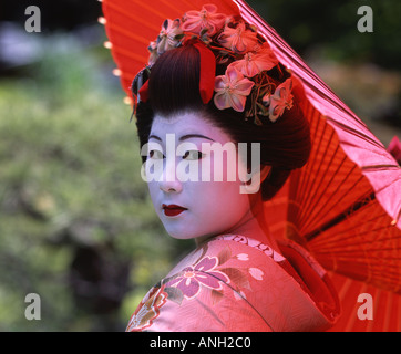 Mädchen gekleidet als Maiko in Kimono mit roten Sonnenschirm Gion Kyoto Japan Stockfoto