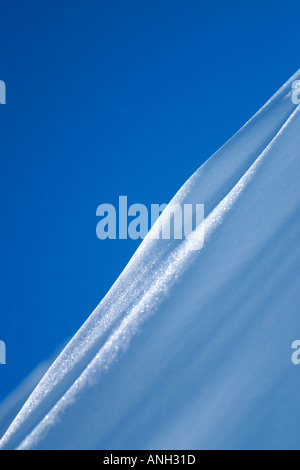 Wind geblasen Schneegrat mit blauem Himmel. Stockfoto