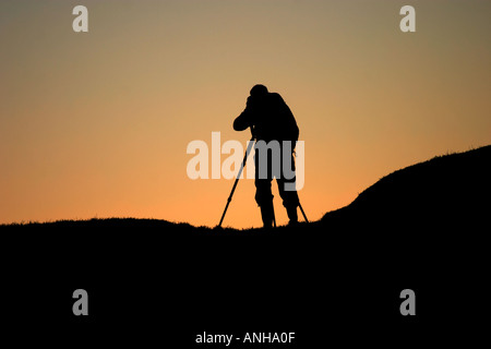 Fotograf gegen Licht des frühen Morgens in Avebury in Wiltshire Stockfoto