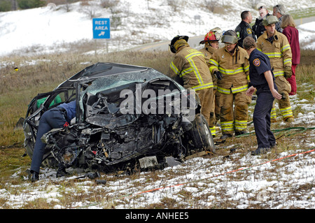Feuerwehrleute kümmern sich um verletzte Crash-Opfer eines Kopfes auf Automobil Absturz Stockfoto