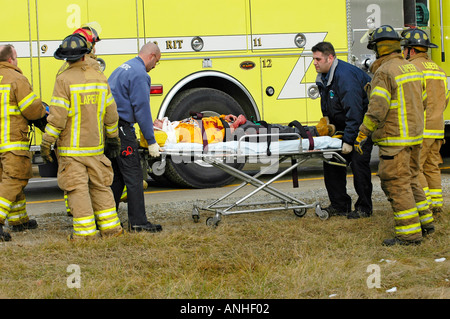 Feuerwehrleute kümmern sich um verletzte Crash-Opfer eines Kopfes auf Automobil Absturz Stockfoto