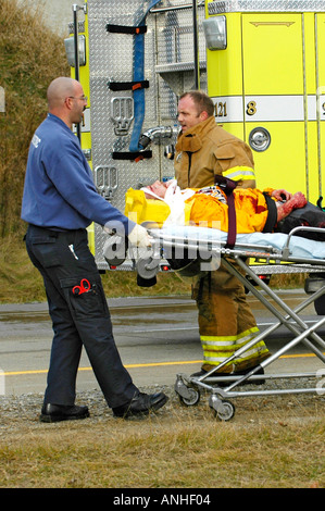 Feuerwehrleute kümmern sich um verletzte Crash-Opfer eines Kopfes auf Automobil Absturz Stockfoto