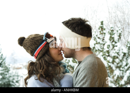 Junges Paar in Winterkleidung, küssen, Seitenansicht Stockfoto