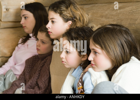 Gruppe von Teenagern und Preteens watching TV zusammen, seitliche Ansicht Stockfoto