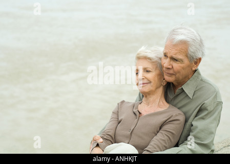 Älteres paar sitzen gemeinsam, Wange an Wange, wegschauen Stockfoto