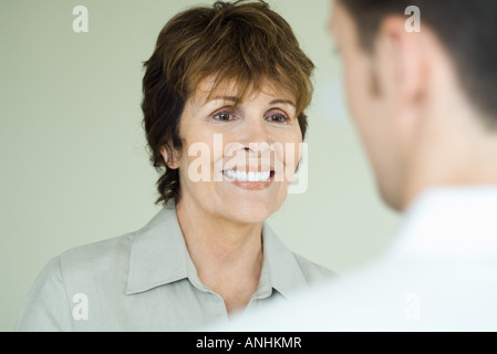 Frau Mann, lächelt über Schulter des Mannes angesehen Stockfoto