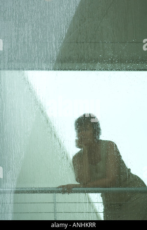Frau, die durch Fenster in Regen
