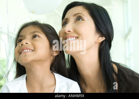 Mutter und Tochter nachschlagen und lächelnd zusammen, Nahaufnahme Stockfoto