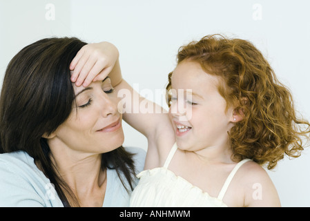 Mutter und Tochter, Mädchen die hand auf der Stirn der Frau Stockfoto