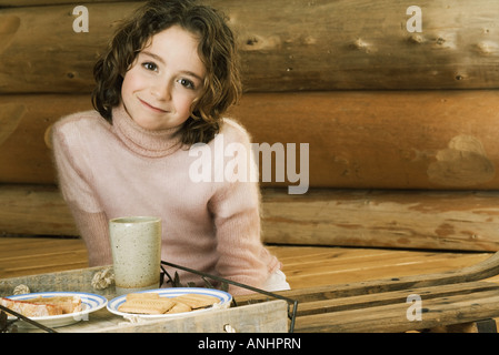 Mädchen mit Snack, lächelnd in die Kamera Stockfoto