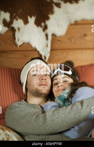 Junges Paar liegend auf der Couch und lächelt in die Kamera Stockfoto