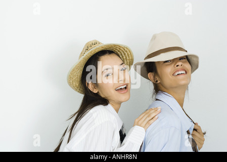 Zwei junge Freundinnen tragen Hüte und Krawatten, lächelnd in die Kamera, eine Platzierung auf der anderen Schulter hand Stockfoto