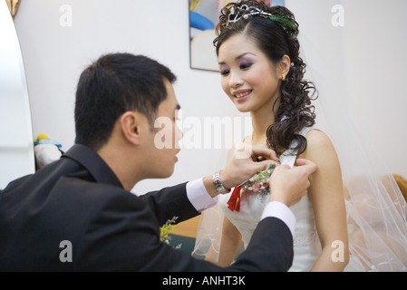 Pinning Corsage auf Brautkleid Bräutigam Stockfoto