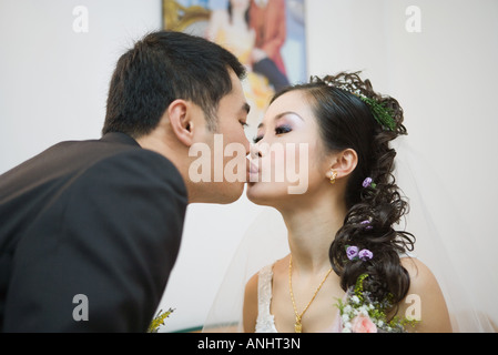 Braut und Bräutigam küssen, Seitenansicht Stockfoto