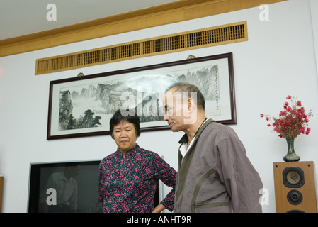 Mann und Frau zusammen im Wohnzimmer stehen, wegschauen Stockfoto