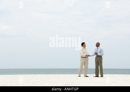 Zwei Geschäftsleute Händeschütteln am Strand Stockfoto