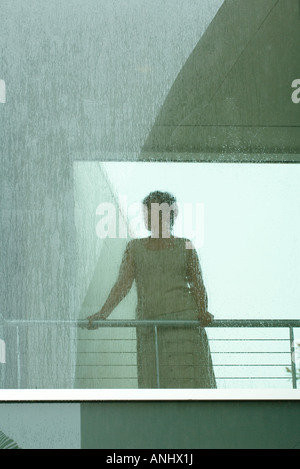 Silhouette der Frau, die durch Fenster in Regen