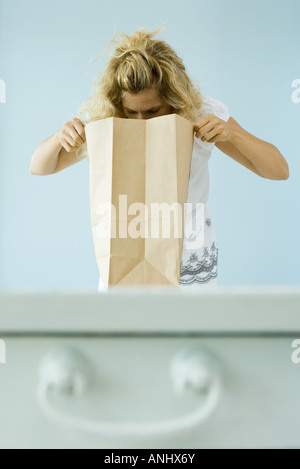 Frau, die in Papier-Einkaufstüte Stockfoto