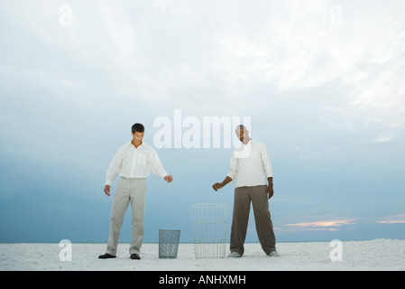 Zwei Männer am Strand halten ihre Hände über Mülltonnen, einen Blick in die Kamera Stockfoto