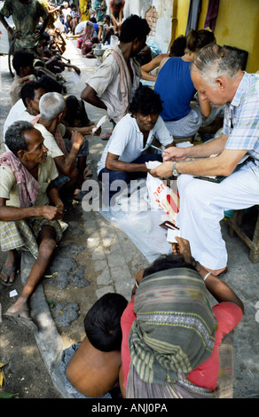 Dr. Jack Preger, Gründer der NGO Calcutta Rescue, behandelt Slumbewohner auf den Straßen von Kolkata, die einzige kostenlose Gesundheitsversorgung, die ihnen zur Verfügung steht. Indien Stockfoto