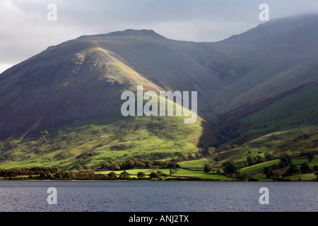 Sonnenlicht leuchtenden Hänge des Lingmell und das Ufer des Wastwater Wasdale mit Scafell Pike im Hintergrund Lake District, Cumbria England Stockfoto