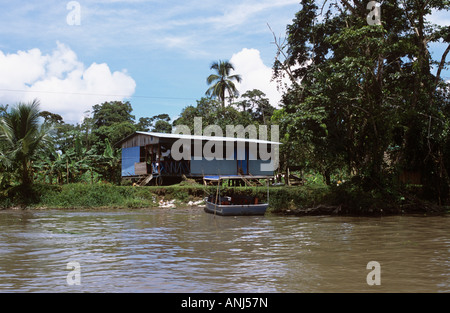 Typisches Dorfhaus am Ufer des Parismina Flusses aus Wasser Boot vertäut am Ufer Parismina Limon Costa Rica Stockfoto