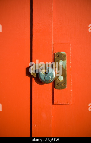 Vorhängeschloss auf orange Holztür Stockfoto