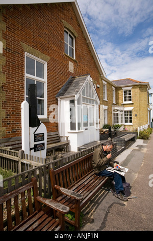 UK Suffolk Southwold Mann saß bei Sonnenschein draußen Segler Lesesaal Stockfoto