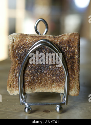 braune verbranntem Toast statt in einem silbernen Toast Rack mit Küche im Hintergrund Stockfoto