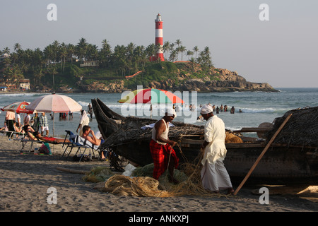 Fischer reparieren ihre Netze am Leuchtturm Strand von Kovalam in Kerala, Südindien Stockfoto