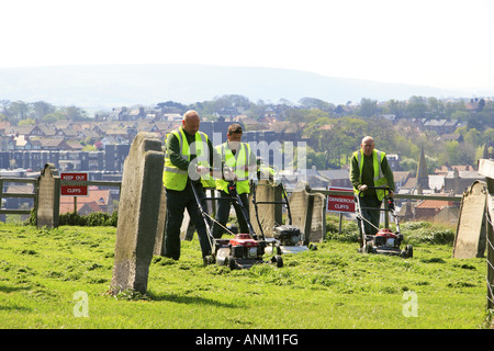 Mähen den Rasen auf dem Friedhof von St. Mary s Church East Cliff Whitby Yorkshire England Stockfoto