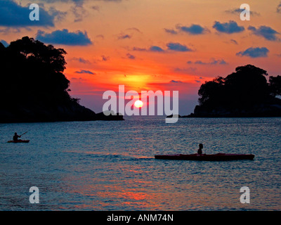 Sonnenuntergang mit Insel und Kanufahrer Silhouette am Salang auf Pulau Tioman Malaysia JPH0033 Stockfoto