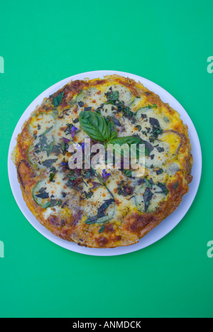 Eine Frittata garniert mit Basilikum und Salbei Blumen Stockfoto