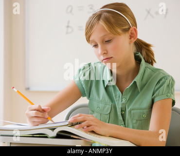 Teenager Mädchen schreiben an Schulbank Stockfoto