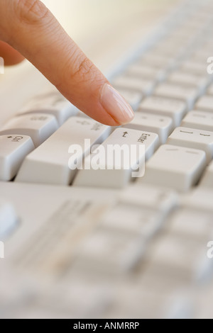 Frau, die Enter-Taste auf der Computertastatur Stockfoto