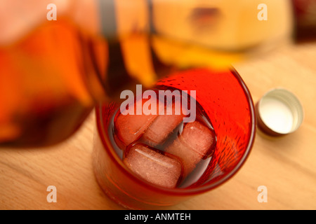 Whisky und Cola Cola Eiswürfel in rot Farbglas Tumbler gießen Stockfoto