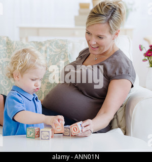 Schwangere Mutter mit Kleinkind spielen Stockfoto