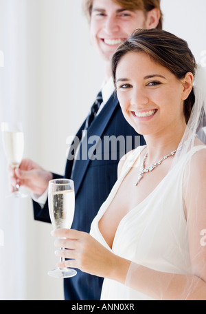Braut und Bräutigam halten Sektgläser Stockfoto