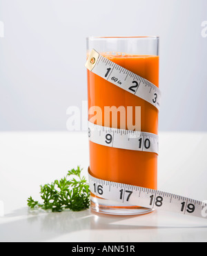 Maßband um Glas Karottensaft gewickelt Stockfoto