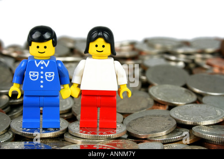 LEGO Mann und Frau stehen auf Münzen - "in the Money"-Konzept Stockfoto