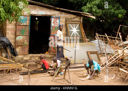 Gambische Männer und jungen tun, Schreinerei und Metallverarbeitung - eine typische am Straßenrand Szene in Gambia, Westafrika Stockfoto