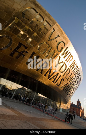 Vertikale Weitwinkel der Sonne auf die zweisprachige Inschrift auf der Vorderseite des Wales Millennium Centre (Canolfan Mileniwm Cymru Stockfoto