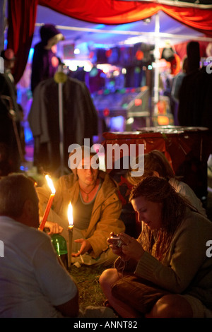 Leute sitzen, plaudern und Rauchen in der Nacht bei Glastonbury Festival für zeitgenössische darstellende Kunst Somerset England UK 2005 Stockfoto