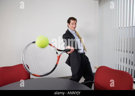 Porträt eines Geschäftsmannes in einem Büro mit dem Tennisspielen. Stockfoto