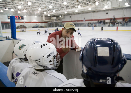 Trainer im Gespräch mit Spielern auf Jugend-Eishockey-team Stockfoto