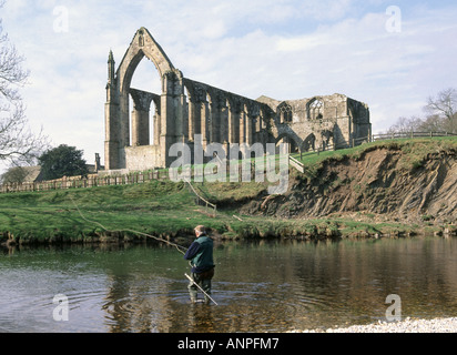 Bolton Abbey Ruine des Augustinus Priorat auch als Bolton Priory & Mann Fliegenfischen im River Wharfe Wharfedale North Yorkshire Dales England UK bekannt Stockfoto