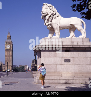 London Tourist neben der Lion Coade-Steinskulptur, die ein Foto von Big Ben und der Westminster Bridge von der Lambeth Side der Themse England UK gemacht hat Stockfoto