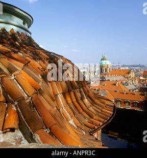 Verwitterten Sie alten Terrakottafliesen Dach, Rahmen Blick auf Kirche und Zentrum von Prag auf einem klaren sonnigen Tag Tschechien Stockfoto
